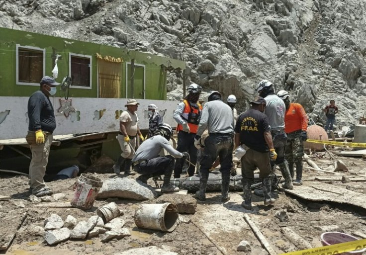Peruvian rescuers carry the body of a victim of the mudslide in Arequipa province in February 2023, where 18 people have been killed and another 20 are missing